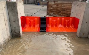 L-shaped flood barriers protecting a building during heavy rainfall.