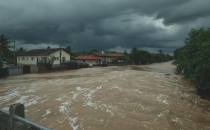 Floodwater approaching a steel flood door protecting a building from flooding